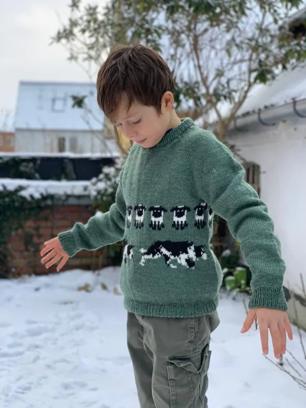 Barn med grøn strik med hundemotiv